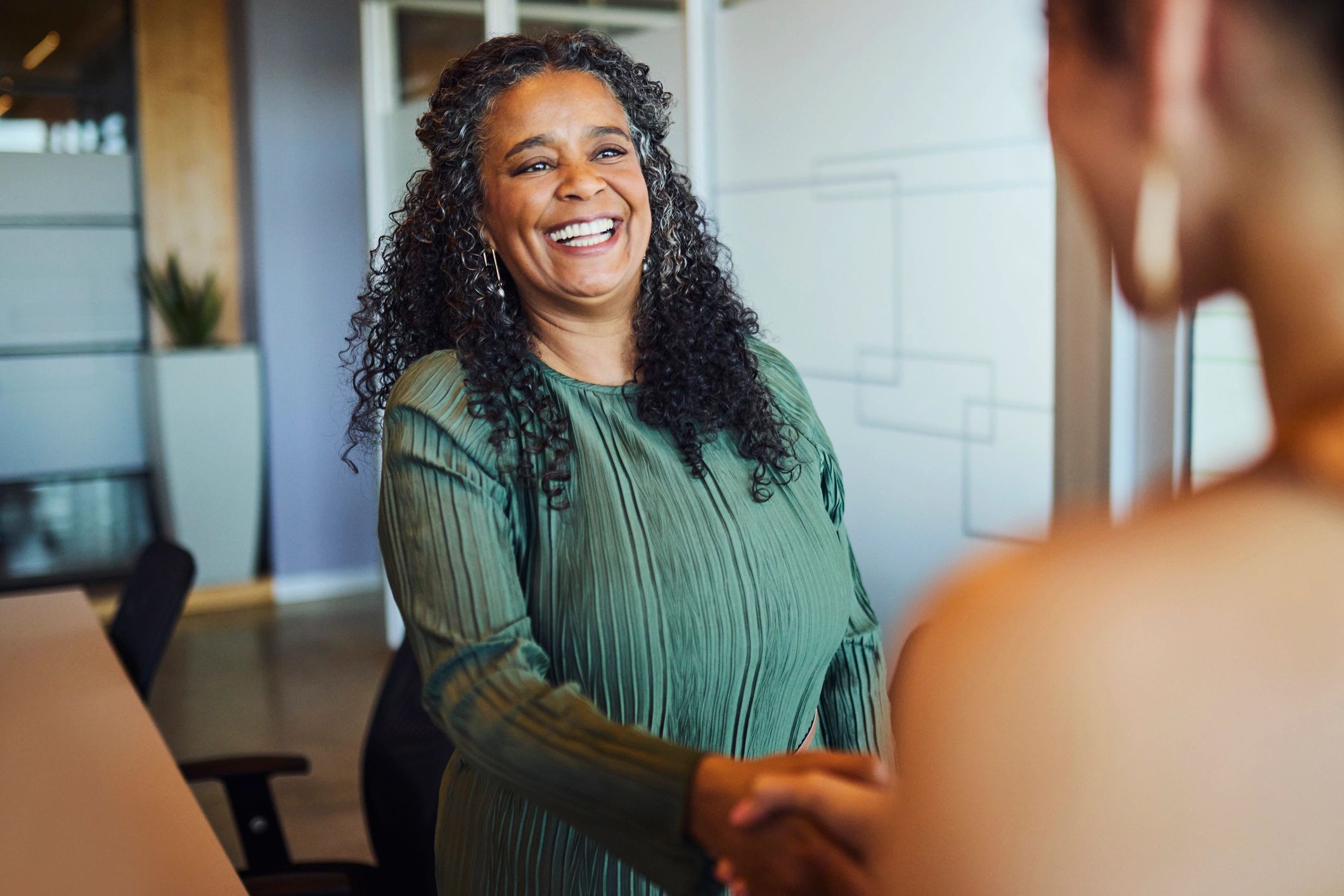 APG partnership meeting handshake in a modern office