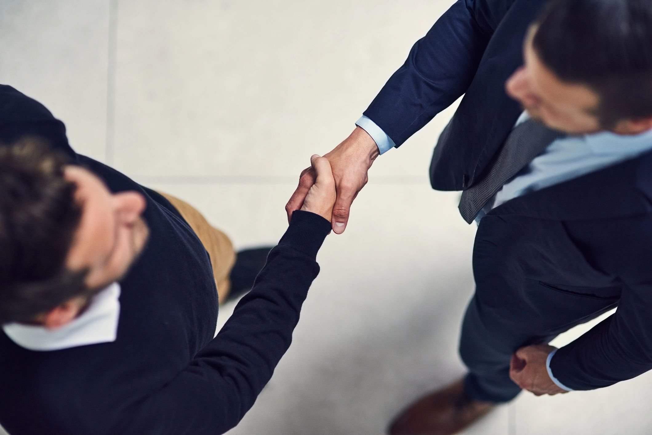 Two professionals shaking hands to represent partnership and trust